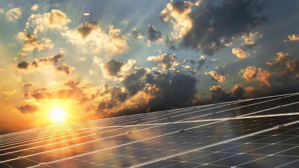 sunset over a row of solar panels