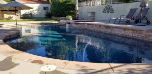 Landscaped backyard with a pool using solar pool heating systems