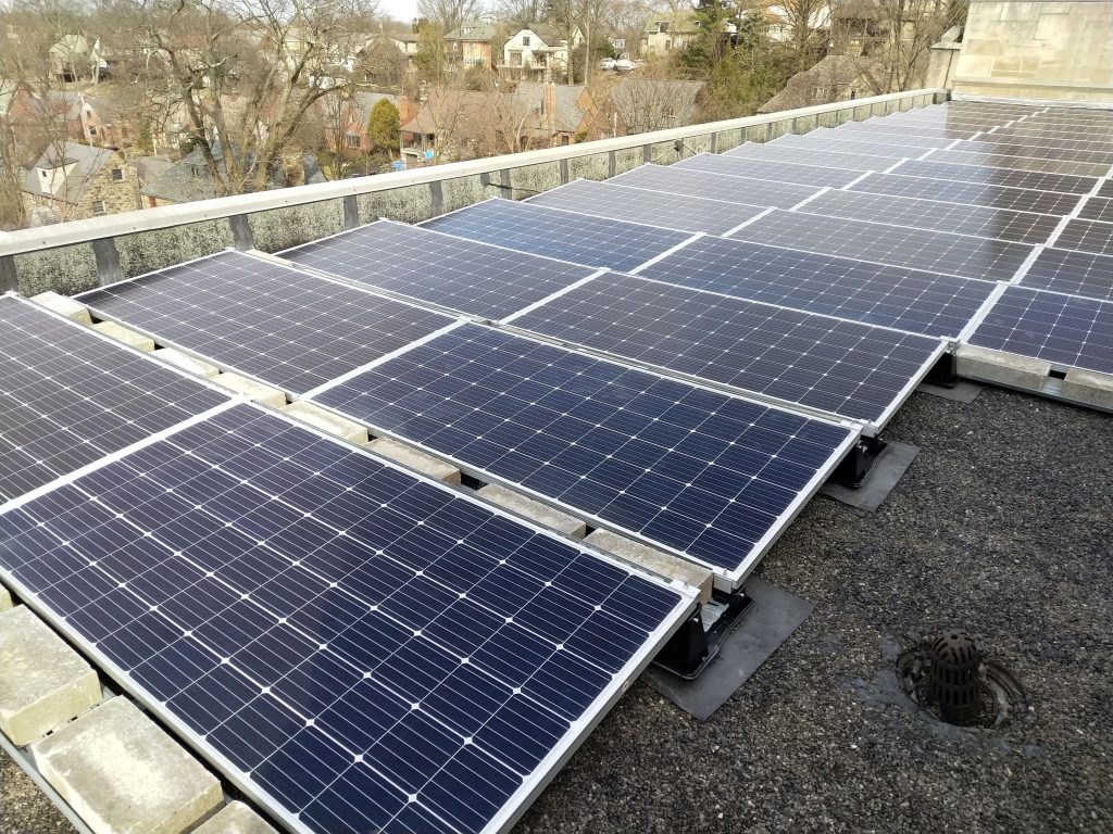 rows of solar panels installed on a building roof